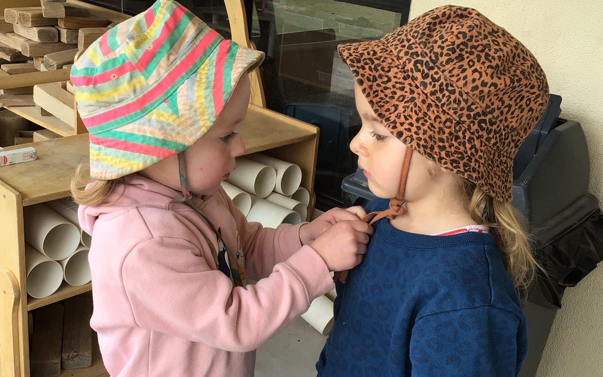 Children are learning to wear hats before heading outdoors at Journey Early Learning Sebastopol.